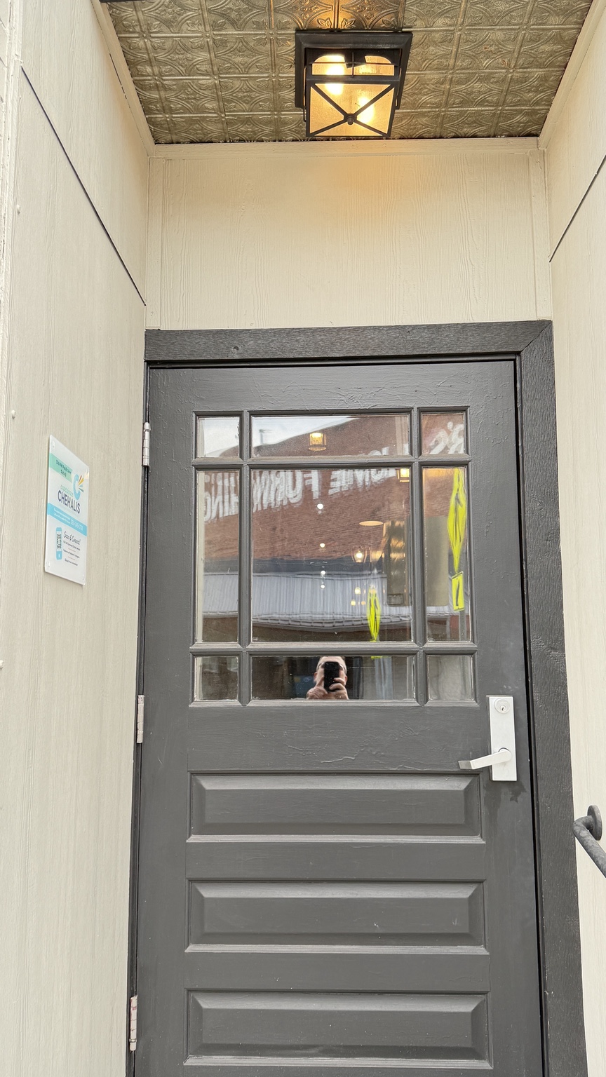 The gray entrance door below the covered entry light